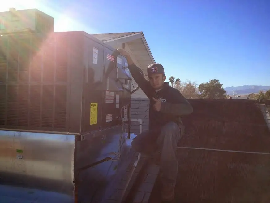 HVAC technician performing Air Duct Repair on a rooftop unit in Martin
